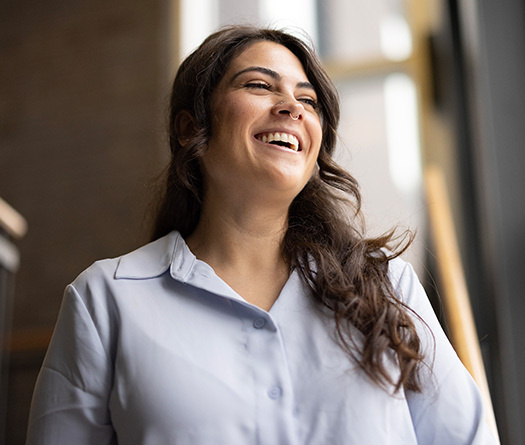 Alice Hollis, une employée du Pôle bien-être étudiant de McGill, sourit avec le regard posé hors champ.