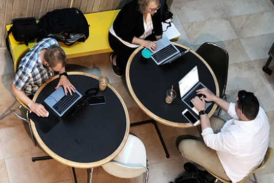 Vue aérienne des personnes travaillant sur des ordinateurs portables lors de tables rondes