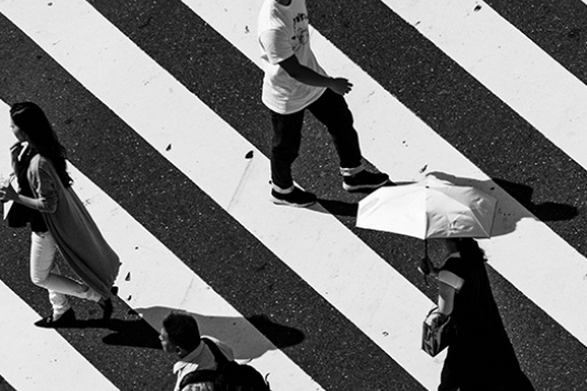 People crossing the street in black and white